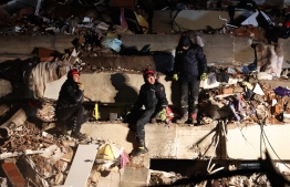 Rescuers search for victims and survivors amidst the rubble of collapsed buildings in Kahramanmaras, Turkey, after a 7.8-magnitude earthquake struck the country's southeast on February 7, 2023. - A major 7.8-magnitude earthquake struck Turkey and Syria, killing more than 3,000 people and flattening thousands of buildings as rescuers dug with bare hands for survivors. (Photo by Adem ALTAN / AFP)
