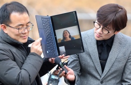 Vietnamese woman Nguyen Thi Thanh is seen on a laptop screen as she speaks to reporters via video call at the Seoul Central District Court in Seoul on February 7, 2023. - A Seoul court delivered a landmark ruling on February 7, holding the South Korean government accountable for a massacre committed by its soldiers in the Vietnam War, ordering it to pay compensation. -- Photo: YONHAP / AFP
