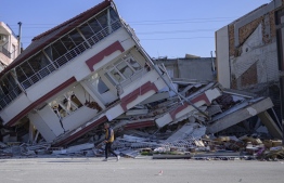 A man walks in front of a destroyed building in Samandag, south of Hatay on February 16, 2023, ten days after a 7.8-magnitude struck the border region of Turkey and Syria. -- Photo: Yasin Akgul / AFP