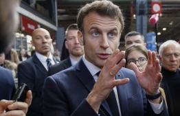 France's President Emmanuel Macron (C), flanked by 'Renaissance' senator Francois Patriat (R), gestures as he visits the 59th edition of the Agriculture fair on its inauguration day in Paris on February 25, 2023. - The 2023 edition of the International Agriculture Fair takes place in Paris from February 25 till March 5, 2023. -- Photo: Ludovic Marin / AFP