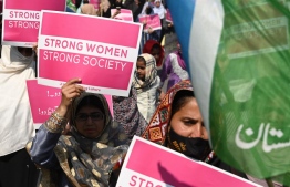 Activists of Jamaat-e-Islami (JI) party hold placards and party flags as they march during a rally to mark the International Women's Day in Lahore on March 8, 2023. -- Photo:  Arif Ali / AFP
