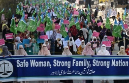 Activists of Jamaat-e-Islami (JI) party hold placards and party flags as they march during a rally to mark the International Women's Day in Lahore on March 8, 2023. -- Photo: Arif Ali / AFP