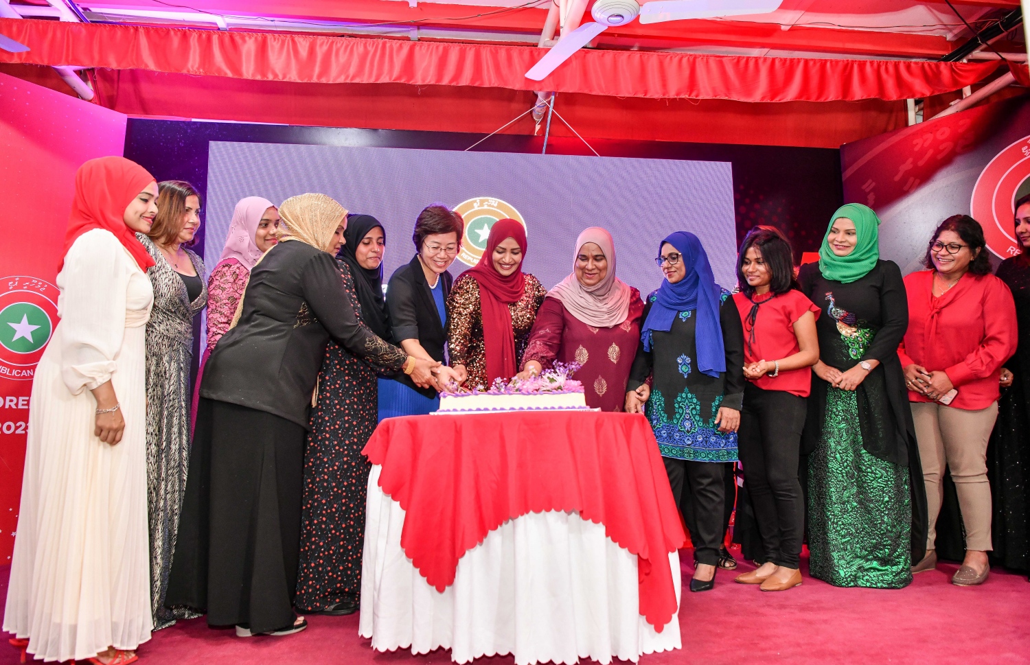 މި އަހަރުގެ އަންހެނުންގެ ދުވަސް ފާހަގަކުރުމަށް މިނިސްޓަރު ނަހުލާ އިސްވެ ބޭއްވި ހަފުލާގައި އޭނާ އާއި ރާއްޖޭގައި ހުންނަވާ ޗައިނާގެ ސަފީރު އަދި ބައެއް އެހެން އަންހެނުން ދުވަހުގެ މުނާސަބަތާ ގުޅޭ ކޭކެއް ފަޅުއްވަނީ.---ފޮޓޯ: ފަޔާޒު މޫސާ| މިހާރު