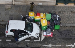 Garbage piles up along a street in Paris on March 14, 2023, since collectors went on strike against the French government's proposed pensions reform. - Thousands of tonnes of garbage have piled up on streets across the French capital after a week of strike action by dustbin collectors against government pension reforms, city hall said on March 12, 2023. -- Photo: Zakaria Abdelkafi / AFP