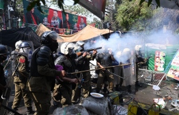 Riot police fire tear gas shells towards supporters of former prime minister Imran Khan gathered near Khan's house to prevent officers from arresting him, in Lahore on March 15, 2023. - Pakistan police appeared on March 15 to have given up an attempt to arrest former prime minister Imran Khan, ending a siege of his residence after violent clashes with hundreds of his supporters. -- Photo: Arif Ali / AFP