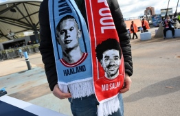 A half and half scarf showing Manchester City's Norwegian striker Erling Haaland and Liverpool's Egyptian striker Mohamed Salah is shown off ahead of the English Premier League football match between Manchester City and Liverpool at the Etihad Stadium in Manchester, north west England, on April 1, 2023. -- Photo: Paul Ellis / AFP
