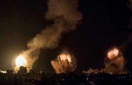 This picture taken early on April 7, 2023 shows explosions in Khan Yunis in the southern Gaza Strip during Israeli air strikes on the Palestinian enclave. -- Photo: Yousef Masoud / AFP