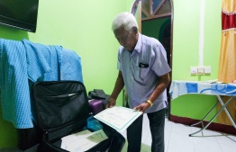 Idrees Aboobakuru showing his credentials in 'Dhivehi Beys' and other related practises, at his home in March 2023. PHOTO: MIHAARU.