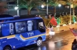 An opposition member standing in front of an RTL Bus, barring it from moving forward during a PPM-PNC protests held in front of the PPM office in Malé on Wednesday, 12th April 2023. PHOTO: TWITTER