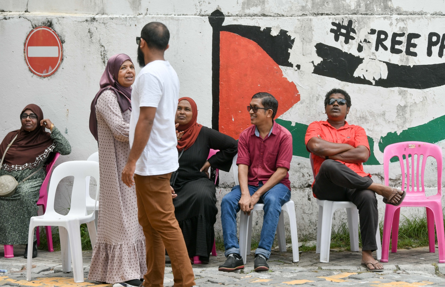 ގުރައިދޫ ދާއިރާގެ ބައި އިލެކްޝަންގެ ވޯޓުލުން އިއްޒުއްދީން ސްކޫލްގައި ކުރިއަށް ދާއިރު އެތަނުގެ ބޭރުގައި މީހުން މަޑުކޮށްގެން.-- ފޮޓޯ: ނިޝާން އަލީ | މިހާރު