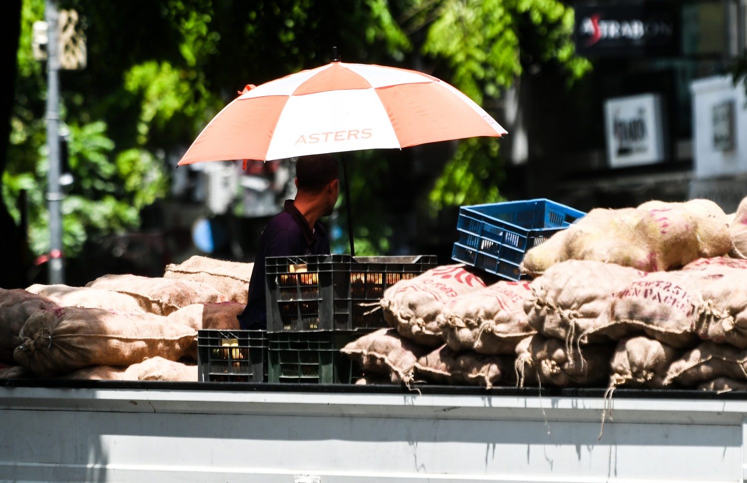 މުދާ ބަރުކޮށްފައި އޮތް ލޮރީއެއްގެ ފަހަތުގައި އިން މީހަކު، ހޫނުން ސަލާމަތްވުމަށް ކުޑައެއް ނަގައިގެން.-- ފޮޓޯ: ފަޔާޒް މޫސާ | މިހާރު