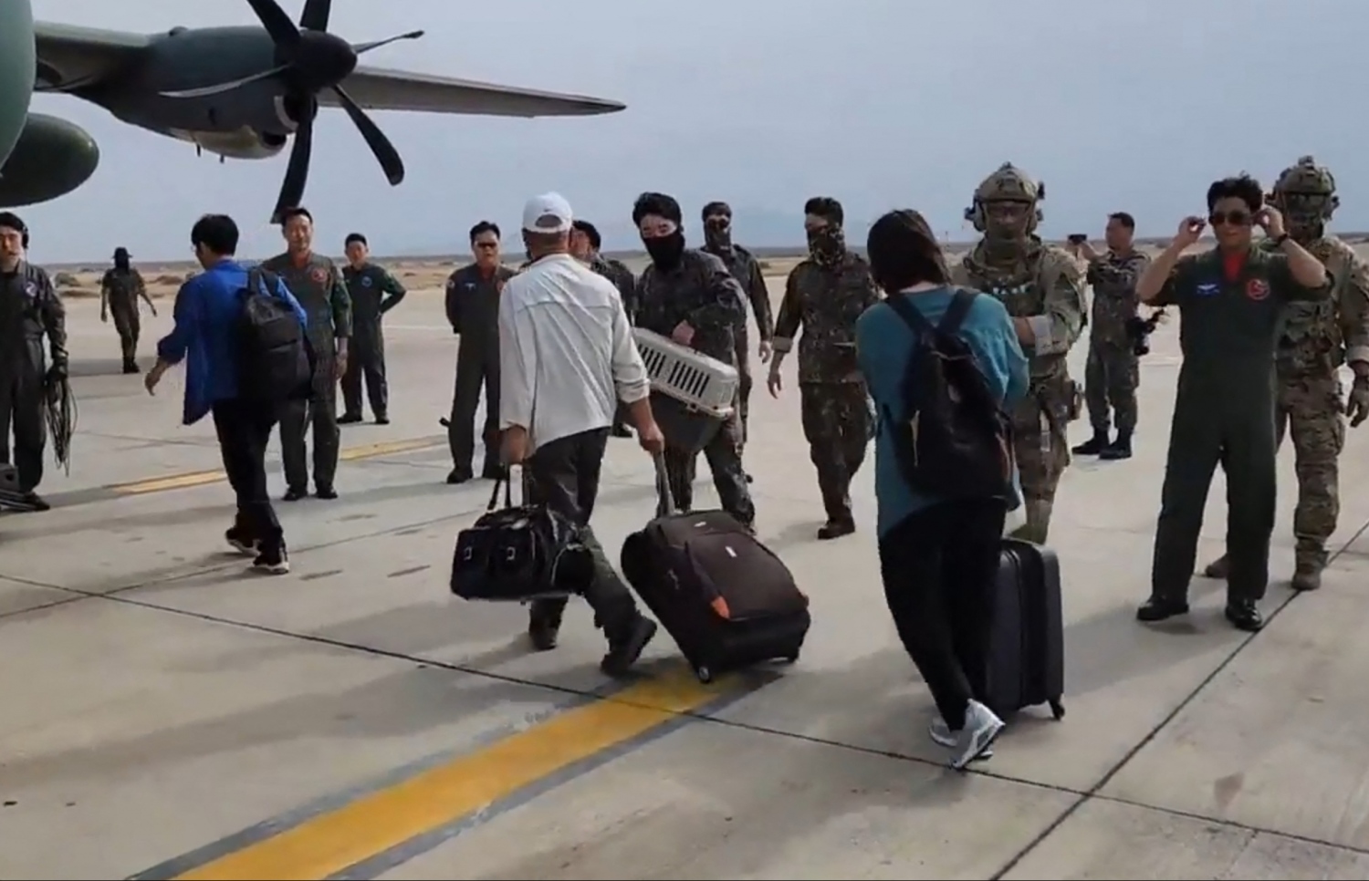 އެޕްރީލް 24، 2023؛ ސޫދާންގައި ތިބި ދެކުނު ކޮރެއާގެ ޑިޕްލޮމެޓުންނާއި ބައެއް އާންމުން، ދެކުނު ކޮރެއާގެ އަސްކަރީ މަތިންދާބޯޓެއްގައި ސޫދާންގެ ޕޯޓް ސޫދާން ވައިގެ ބަނދަރުން ފުރަނީ. --އޭއެފްޕީ