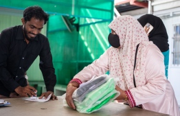 A woman purchasing a pack of bags sold by WAMCO for garbage collection. Last month, MVR 1.1 million was collected as plastic bag taxes. -- Photo: Fayaz Moosa