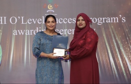 Minister Dr. Aishath Ali (L) awarding a teacher for their hard work in improving student performances on Wednesday, May 3, 2023 -- Photo: Education Ministry