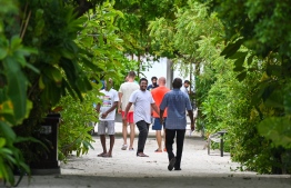 A group of tourists walk through Vaavu atoll Thinadhoo on May 10, 2023: industry insiders believe the decreased revenue is due to lower room prices this year, than compared to last year -- Photo: Fayaz Moosa / Mihaaru
