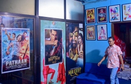 In this photograph taken on May 6, 2023, film distributor Anonno Mamun walks past posters of bollywood films 'Pathaan' and 'Kisi Ka Bhai Kisi Ki Jaan' at his office in Dhaka. Thousands flocked to cinemas in Dhaka on May 12 as Shah Rukh Khan's blockbuster "Pathaan" hit the big screens, the first Bollywood movie to get a full release in Bangladesh in more than half a century. -- Photo: Munir Uz Zaman / AFP