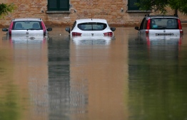 Flooded cars are pictured in a street of Cesena on May 17, 2023 after heavy rains caused major floodings in central Italy. Trains were stopped and schools were closed in many towns while people were asked to leave the ground floors of their homes and to avoid going out, and five people have died after the floodings across Italy's northern Emilia Romagna region. -- Photo: Alessandro Serrano / AFP