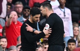 Referee Andrew Madley (R) speaks to Arsenal's Spanish manager Mikel Arteta during the English Premier League football match between Arsenal and Brighton and Hove Albion at the Emirates Stadium in London on May 14, 2023. -- Photo: Glyn Kirk / AFP