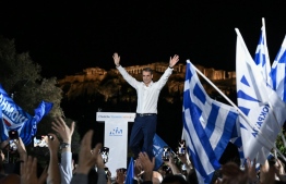 Greek Prime Minister and leader of the conservative New Democracy party Kyriakos Mitsotakis gestures as he addresses a speech to his party's supporters during his last pre-election rally ahead of Greece's general elections planned for May 21, with the Acropolis hill in the background, in Athens on May 19, 2023. -- Photo: Aris Messinis / AFP