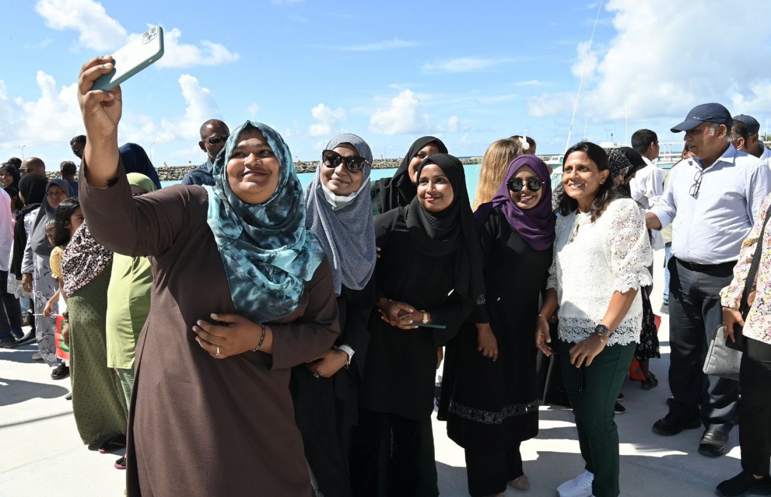 ފ. ދަރަނބޫދޫގައި ރައީސްގެ ދެކަނބަލުންނަށް މަރުހަބާ ކިޔަން ގޮސް ތިބި ބަޔަކު ފަސްޓް ލޭޑީ އަހްމަދު ފަޒްނާއާއެކު ސެލްފީއެއް ނަގަނީ.-- ފޮޓޯ: ރައީސް އޮފީސް