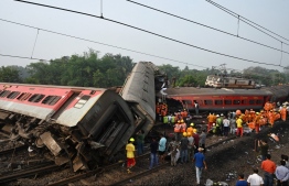 Rescue workers gather around damaged carriages during search for survivors at the accident site of a three-train collision near Balasore, about 200 km (125 miles) from the state capital Bhubaneswar in the eastern state of Odisha, on June 3, 2023. At least 288 people were killed and more than 850 injured in a horrific three-train collision in India, officials said on June 3, the country's deadliest rail accident in more than 20 years. -- Photo: Dibyangshu Sarkar/ AFP