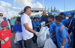 Maldives Vice President Faisal Naseem helps a few school students in cleaning up the beachside streets-- Photo: Twitter