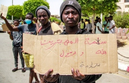 A sub-Saharan migrant holds a sign showing slogans during a protest against the dire conditions of migrants in Tunisia's coastal central city of Sfax on July 7, 2023, after the death of a young Tunisian stabbed in an altercation between locals and migrants. Hundreds of African migrants were stranded in dire conditions in a desert area of southern Tunisia on July 6 after being expelled from the port city of Sfax, witnesses told AFP. Racial tensions flared this week into violence targeting migrants from sub-Saharan African countries, with dozens fleeing the city or being forcibly evicted. -- Photo: Houssem Zouari / AFP