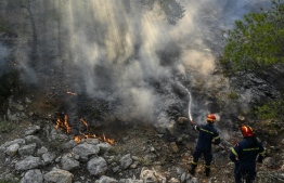 Firefighters try to control a wildfire in New Peramos, near Athens, on July 19, 2023. Extreme heat was forecast across the globe on July 19, 2023, as wildfires raged and health warnings were in place in parts of Asia, Europe and North America. Firefighters battled blazes in parts of Greece and the Canary Islands, while Spain issued heat alerts and some children in Italy's Sardinia were told to stay away from sports. -- Photo: Louisa Gouliamaki / AFP