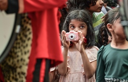 A child taking a photograph during the military parade held to celebrate Maldives' 58th Independence Day -- Photo: Nishan Ali / Mihaaru