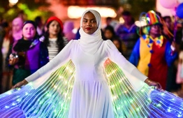 An STO employee wearing a dress that lights up during the float procession -- Photo: Nishan Ali / Mihaaru
