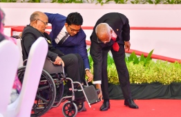 President Ibrahim Mohamed Solih assists a recipient of the National Award for Public Service in a wheelchair during the official ceremony held today -- Photo: President's Office
