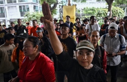 A pro-democracy protester holds up the three-finger salute during a protest after Puea Thai held a press conference announcing that the Move Forward Party (MFP) will no longer be part of the eight-party coalition at Puea Thai Party's headquarters in Bangkok on August 2, 2023. The reformist party that won Thailand's general election was on August 2 excluded from a coalition trying to form a government, as lawmakers seek a way around resistance from military and pro-royalist senators. -- Photo: Lillian  Suwanrumpha / AFP