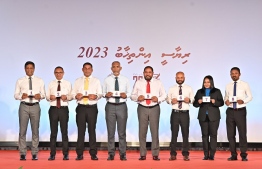 Some of the candidates and their election agents display their ballot numbers and pose for a photo at the ceremony held in Elections Commission to determine candidates ballot order for the upcoming presidential election --Photo: Nishan Ali