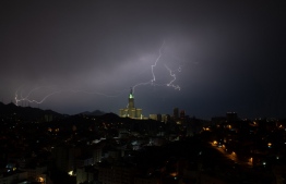 A picture taken on August 22, 2023 shows lightning over Mecca's clock tower in Saudi Arabia. Fierce storms closed schools on August 23 the desert kingdom's Mecca region, home to the holy Grand Mosque which was lashed by heavy rains and wind overnight, witnesses said. -- Photo: Hammad Al-Huthali / AFP