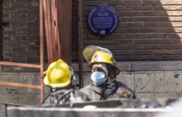 EDITORS NOTE:  / A historical plaque can be seen next to the entrance of a burned apartment block in Johannesburg on August 31, 2023. More than 70 people have died in a fire that engulfed a five-storey building in central Johannesburg on August 31, 2023, the South African city's emergency services said. -- Photo: Guillem Sartorio / AFP