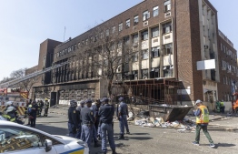 EDITORS NOTE:  / Firefighters and members of the South African Police Service (SAPS) are deployed in front of a burned apartment block in Johannesburg on August 31, 2023. More than 70 people have died in a fire that engulfed a five-storey building in central Johannesburg on August 31, 2023, the South African city's emergency services said. --  Photo: Guillem Sartorio / AFP