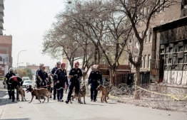South African Police Service (SAPS) K-9 Unit leave a burned apartment block in Johannesburg on September 1, 2023. More than 70 people have died in a fire that engulfed a five-storey building in central Johannesburg on August 31, 2023, the South African city's emergency services said. -- Photo: Luca Sola / AFP