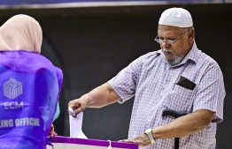 A voter places his ballot paper into a vote box-- Photo: Fayaz Moosa | Mihaaru