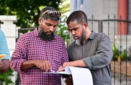 An election official checks voters list amid polling-- Photo: Fayaz Moosa | Mihaaru