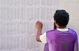 An official pastes voters lists-- Photo: Fayaz Moosa | Mihaaru