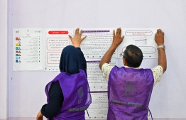 Elections officials pasting rules and regulations of the polling-- Photo: Fayaz Moosa | Mihaaru