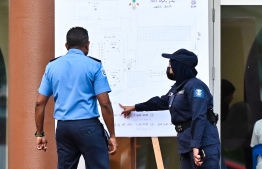 Officers of the Maldives Police Service inspect a chart highlighting voting stations-- Photo: Nishan Ali | Mihaaru