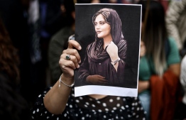 (FILES) A protester holds a portrait of Mahsa Amini during a demonstration in her support in front of the Iranian embassy in Brussels on September 23, 2022, following the death of an Iranian woman after her arrest by the country's morality police in Tehran. A year after the death of Mahsa Amini sparked unrest across Iran, the issue of the hijab remains a sore spot -- but a crippling economic crisis has left many preoccupied with making ends meet. -- Photo: Kenzo Tribouillard / AFP