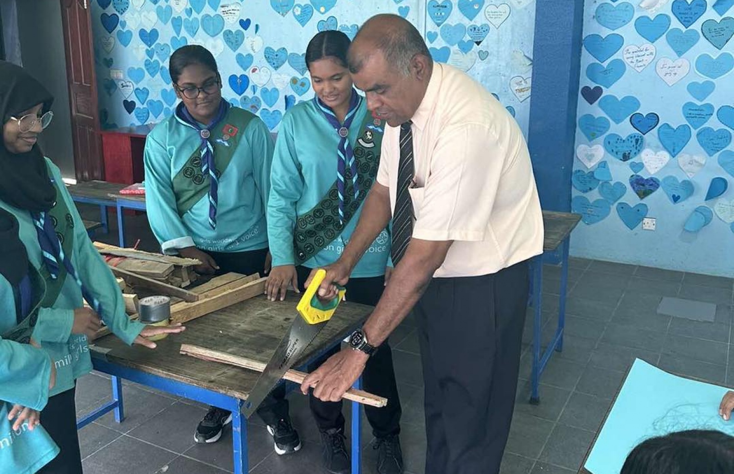 ޖަމާލުއްދިީން ސްކޫލުގައި ބޭއްވި ހަރަކާތެއްގައި، އެ ސްކޫލުގެ ދަރިވަރުންނާއެކު ޕްރިންސިޕަލްގެ މަގާމުގައި ހަސަން ހުންނެވިއިރު ބައިވެރިވެވަޑައިގަންނަވަނީ.-- ފޮޓޯ: ޖަމާލުއްދީން ސްކޫލު