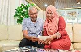 President Dr. Mohamed Muizzu and first Lady Sajidha Mohamed in an exclusive interview with Mihaaru News: the first couple reminisce over their family photos. They have moved to Muliaage as of Monday. -- Photo: Fayaz Moosa