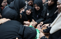 Women mourn over the body of one of three Palestinians killed in an Israeli raid on the Jenin camp for Palestinian refugees in the occupied West Bank, in the camp on September 20, 2023. The three Palestinians were killed the previous day, a Palestinian health ministry statement said, adding that "about 30 people were wounded by occupation (Israeli) fire in Jenin". The Israeli army confirmed troops were operating in Jenin late on September 19 and said a drone struck the camp, without elaborating. -- Photo: Zain Jaafar / AFP