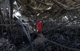 A firefighter checks the damage in an event hall in Qaraqosh, also known as Hamdaniyah, after a fire broke out during a wedding, killing at least 100 people and injuring more than 150, on September 27, 2023. -- Photo: Safin Hamid / AFP