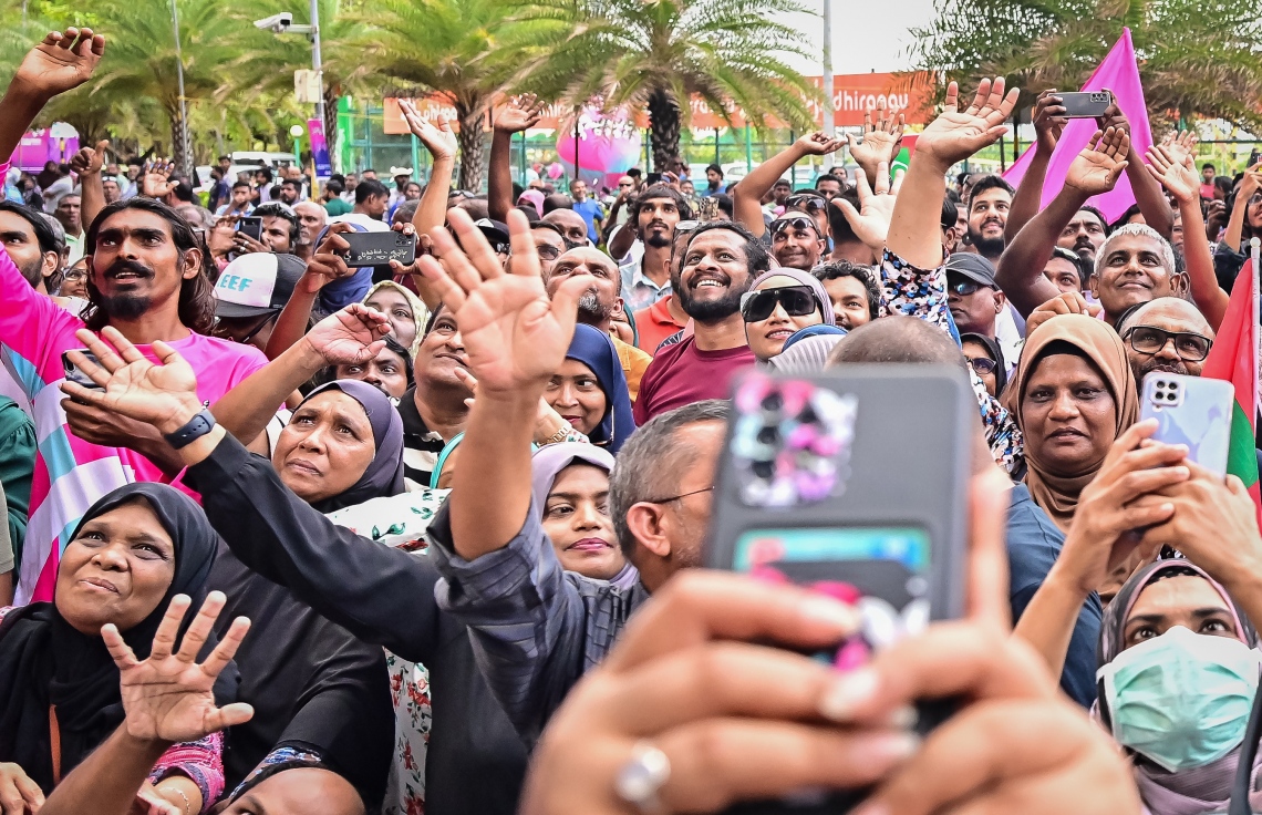 ކުރީގެ ރައީސް ޔާމީން ޖަލުން ގޭ ބަންދަށް ބަދަލުކުރުމުން އެ މަނިކުފާނު ގެކޮޅުގެ ކުޑަދޮރުން ސަޕޯޓަރުންނަށް ވޭވް ކުރައްވާއިރު އެ މީހުން އުފަލުން އެކަން ބަލައިގަންނަނީ: ޔާމީނަށް މަރުހަބާ ކިޔަން އެތައް ސަތޭކަ ބަޔަކު އެ މަނިކުފާނުގެ ގެކޮޅު ކައިރި އަށް ޖަމާވި. ޔާމީނަށް އިސްވެ މަރުހަބާ ދެންނެވީ އިންތިހާބީ ރައީސް ޑރ. މުހައްމަދު މުއިއްޒު.---ފޮޓޯ: ނިޝާން އަލީ| މިހާރު