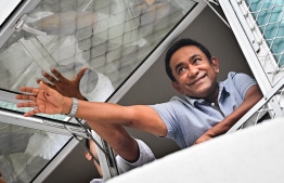 Yameen at his home, waving to his supporters outside.