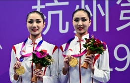 Gold medallists China’s Wang Liuyi and Wang Qianyi celebrate on the podium after the finals of the women's duet free artistic swimming event during the Hangzhou 2022 Asian Games in Hangzhou in China's eastern Zhejiang province on October 7, 2023. -- Photo: Manan Vatsyayana / AFP